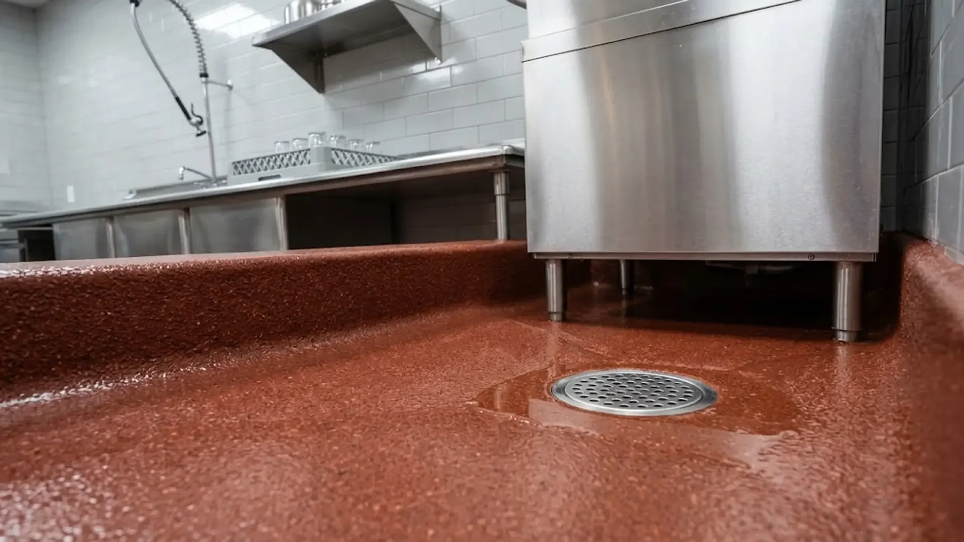Floor drain and curved floor-to-wall base in a commercial kitchen
